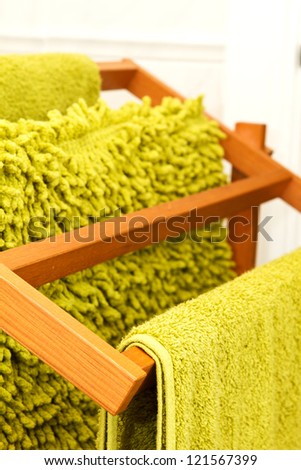 Green towels hanging on a wooden towel rail