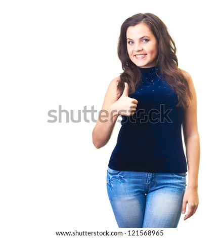 Attractive smiling young woman in a blue shirt and blue jeans shows her right hand thumbs up. Isolated on white background