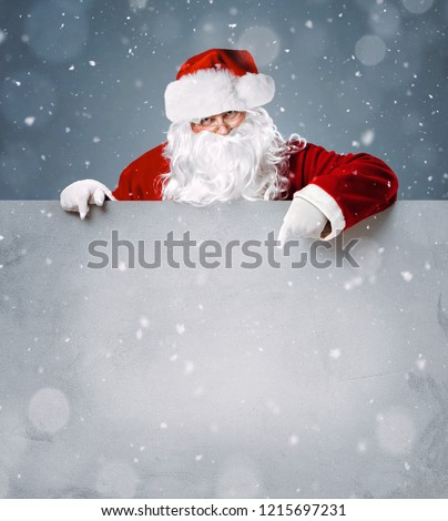 Santa Claus pointing in blank advertisement banner with copy space Royalty-Free Stock Photo #1215697231