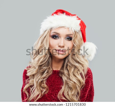 Smiling girl in santa clause hat. Cute Cristmas woman portrait