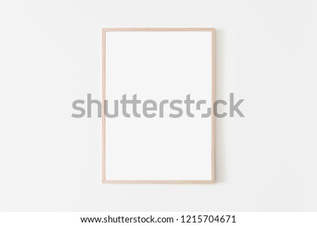 Portrait large 50x70, 20x28, a3,a4, Wooden frame mockup on white wall. Poster mockup. Clean, modern, minimal frame. Empty fra.me Indoor interior, show text or product Royalty-Free Stock Photo #1215704671