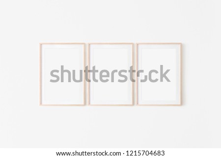 Set of three large 50x70, 20x28, a3,a4, Wooden frame mockup with backing board on white wall. Poster mockup. Clean, modern, minimal frame. Empty fra.me Indoor interior, show text or product Royalty-Free Stock Photo #1215704683