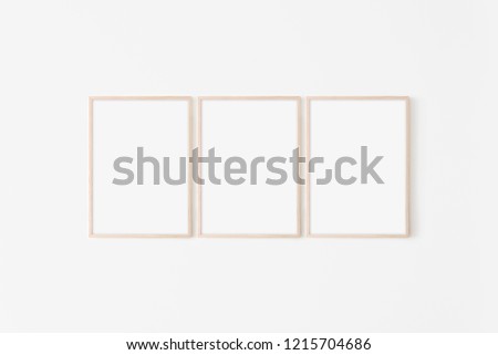 Set of three large 50x70, 20x28, a3,a4, Wooden frame mockup on white wall. Poster mockup. Clean, modern, minimal frame. Empty fra.me Indoor interior, show text or product Royalty-Free Stock Photo #1215704686