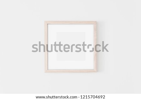 Square Wooden frame mockup with passe-partout on white wall. Poster mockup. Clean, modern, minimal frame. Empty fra.me Indoor interior, show text or product