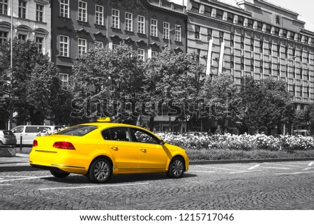 Yellow taxi parked on city street. Black and white. Selective color effect
