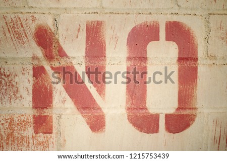 NO painted on a brick wall in big red letters