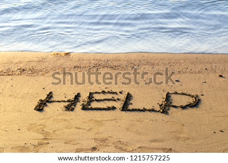 HELP inscription on sand.