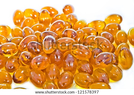 Pile of Rice bran oil pills capsule with similar color to fish oil on white isolated background. They are famous supplementary food for Omega 3 nutrition and used for alternative medicine.