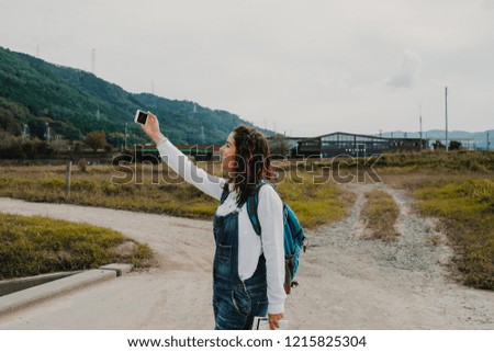Young and sweet woman enjoying her trip around Japan. Taking herself some pictures while travelling around the world. Travel photography.