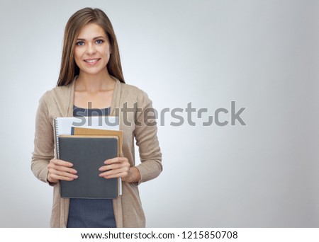 Young smiling woman teacher holding work books. Isolated studio portrait.