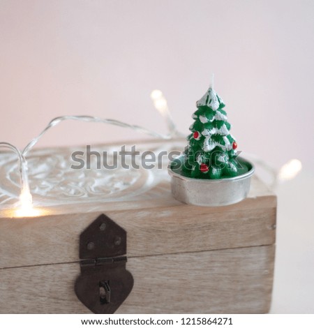 Closeup view of a vintage jewellery box with a Christmas tree candle and some garland lights