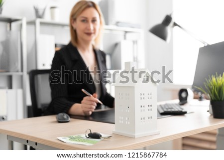 Photo with depth of field, a dedicated focus on the layout of the house. Young girl working in the office.