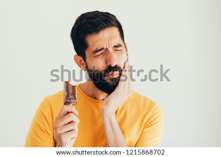 Man have sensitive teeth with ice on white background Royalty-Free Stock Photo #1215868702