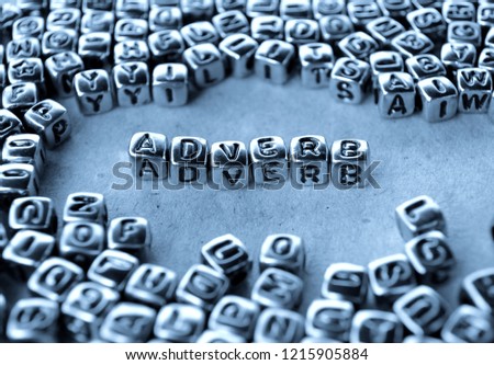 Adverb - Word from Metal Blocks on Paper - Concept Photo on Table
