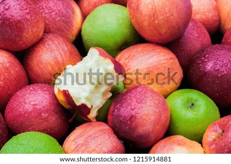 Apple core leftover among heap of fresh red and green apples mix closeup side view Royalty-Free Stock Photo #1215914881