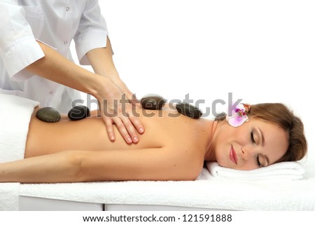 beautiful woman in spa salon with spa stones  getting massage, isolated on white
