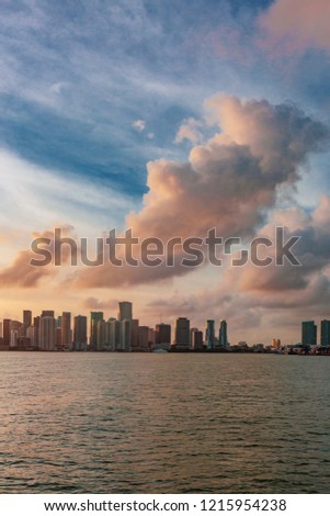 View of skyline of downtown Miami from the sea under sky and clouds at sunset, in Florida, USA