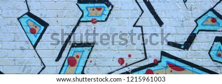 Fragment of graffiti drawings. The old wall decorated with paint stains in the style of street art culture. Colored background texture in cold tones