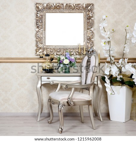 A fragment of a retro interior with a chair and table, on which is a telephone and a vase of flowers. Above the table hangs an empty picture frame for your photo