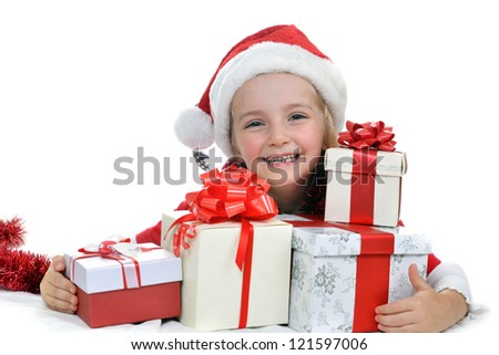 little girl in red santa cap with christmas presents