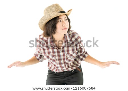 Young pretty woman in a cowboy hat and plaid shirt posing in studio with isolated on white background