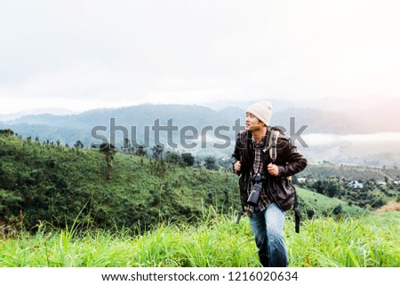 male traveler photographer fascinated by illuminated nature mountains at morning time.