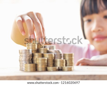 Child stacking coin on desk, Invest your money to get in come,growing business and future concept