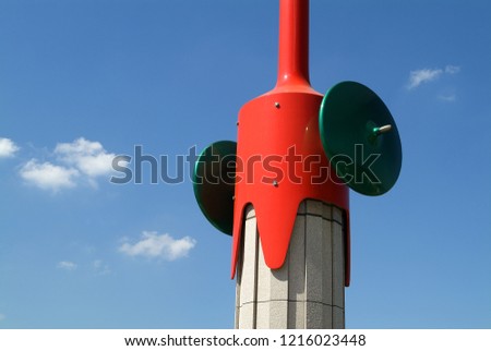 Sunny and clean blue sky and white clouds, red wind direction meter, bright color contrast.