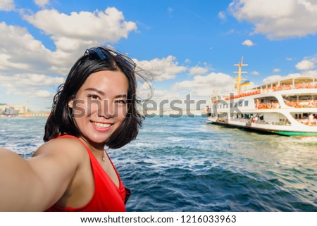 Beautiful Chinese woman takes selfie with view of Bosphorus on background in Istanbul,Turkey