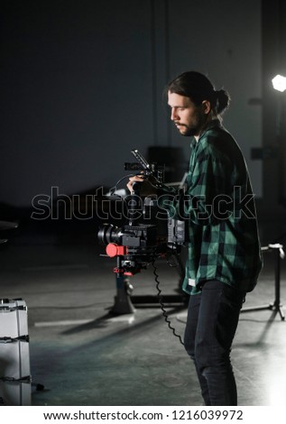 Professional videographer holding camera on 3-axis gimbal. Videographer using steadicam. Pro equipment helps to make high quality video without shaking.