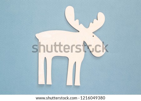 White wooden stencil of deer on a blue background.