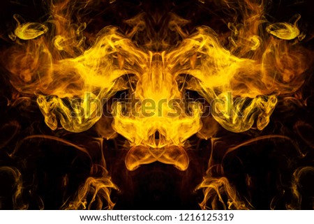 Fantasy print for clothes: t-shirts, sweatshirts.  Colorful yellow and orange smoke in the form of a skull, monster, dragon on a black isolated background. Background from the smoke of vape
