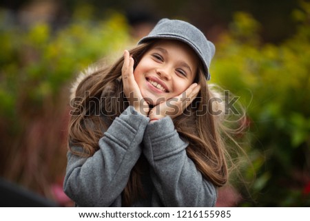 Photo of smiling girl in gray hat and coat
