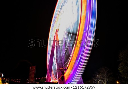 colorful illuminated big ferris wheel on the festival by night