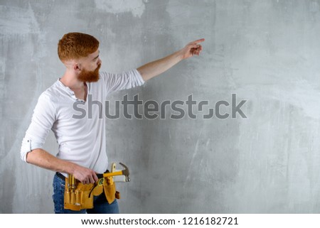 Bearded builder, master finisher with hand gesture
