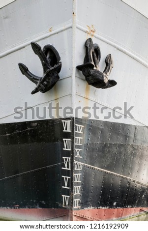 Steel ship bow, with double anchor. Industrial transportation background. Detailed nautical. Close up metal ship with rivets. Front of vessel. Harbor marine object. 