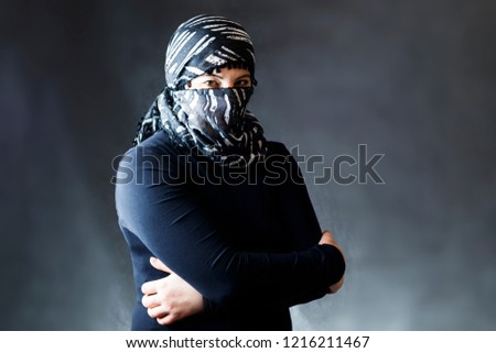 Portrait of a girl in a scarf in a black jacket on a dark background