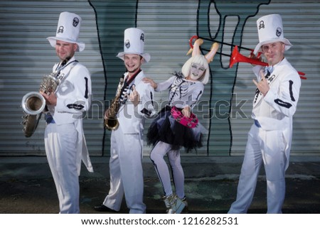 Halloween party on street.Four musicians play musical instruments.