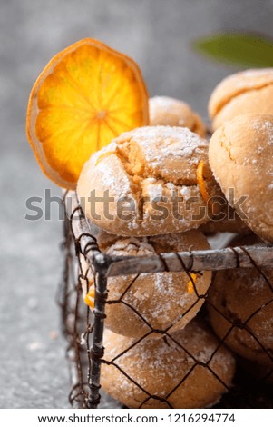 Homemade orange crinkle cookies with powdered sugar icing on gray background, vertical composition 