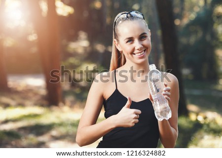 Happy athletic girl drinking water bottle at park banner panorama crop