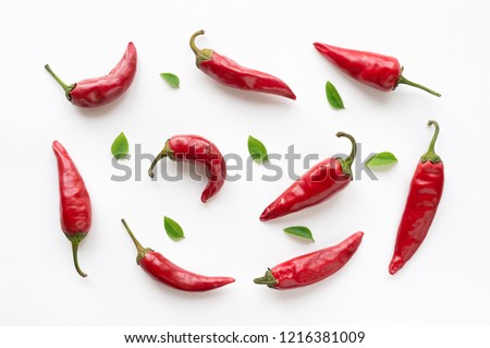 Red hot chilli peppers with green leaves on white background. Food pattern.  Royalty-Free Stock Photo #1216381009