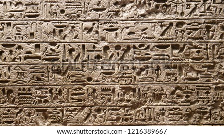 CLOSE UP: Traditional Egyptian lettering and symbols carved into a large slab of solid stone. Detailed view of beautiful hieroglyphs carved into a stone wall in a museum of ancient history in Rome.