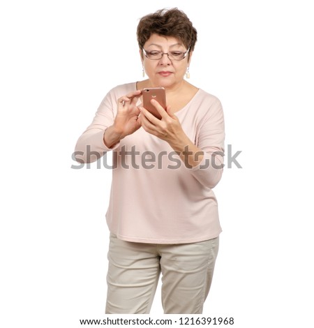 Beautiful woman aged with glasses in the hands of a mobile phone on a white background. Isolation