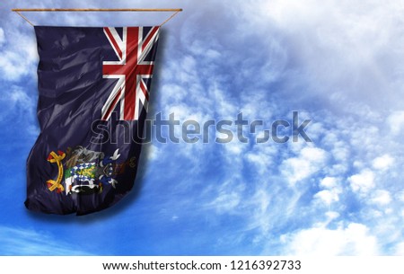 Flag of South Georgia and the South Sandwich Islands. Vertical flag, against blue sky with place for your text
