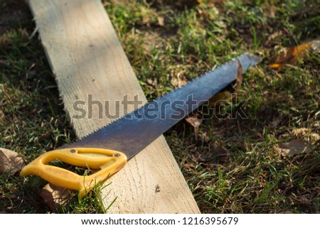 hacksaw on the grass with a Board