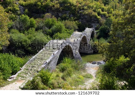 Old Kalogeriko triple arched stone bridge on Vikos canyon, Zagorohoria, Greece Royalty-Free Stock Photo #121639702