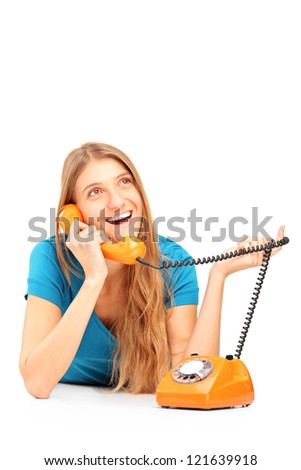 Smiling woman talking on an old styled phone isolated on white background