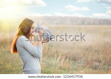 the girl with the rabbit.happy little girl holding cute fluffy Bunny.Friendship with Easter Bunny. Spring photo with beautiful young girl with her Bunny. Girl is holding a cute little rabbit