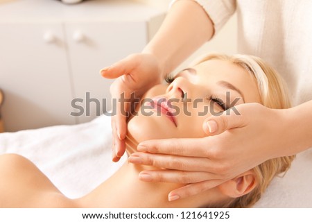 picture of calm beautiful woman in massage salon (focus on hands)