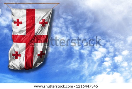 Flag of Georgia. Vertical flag, against blue sky with place for your text